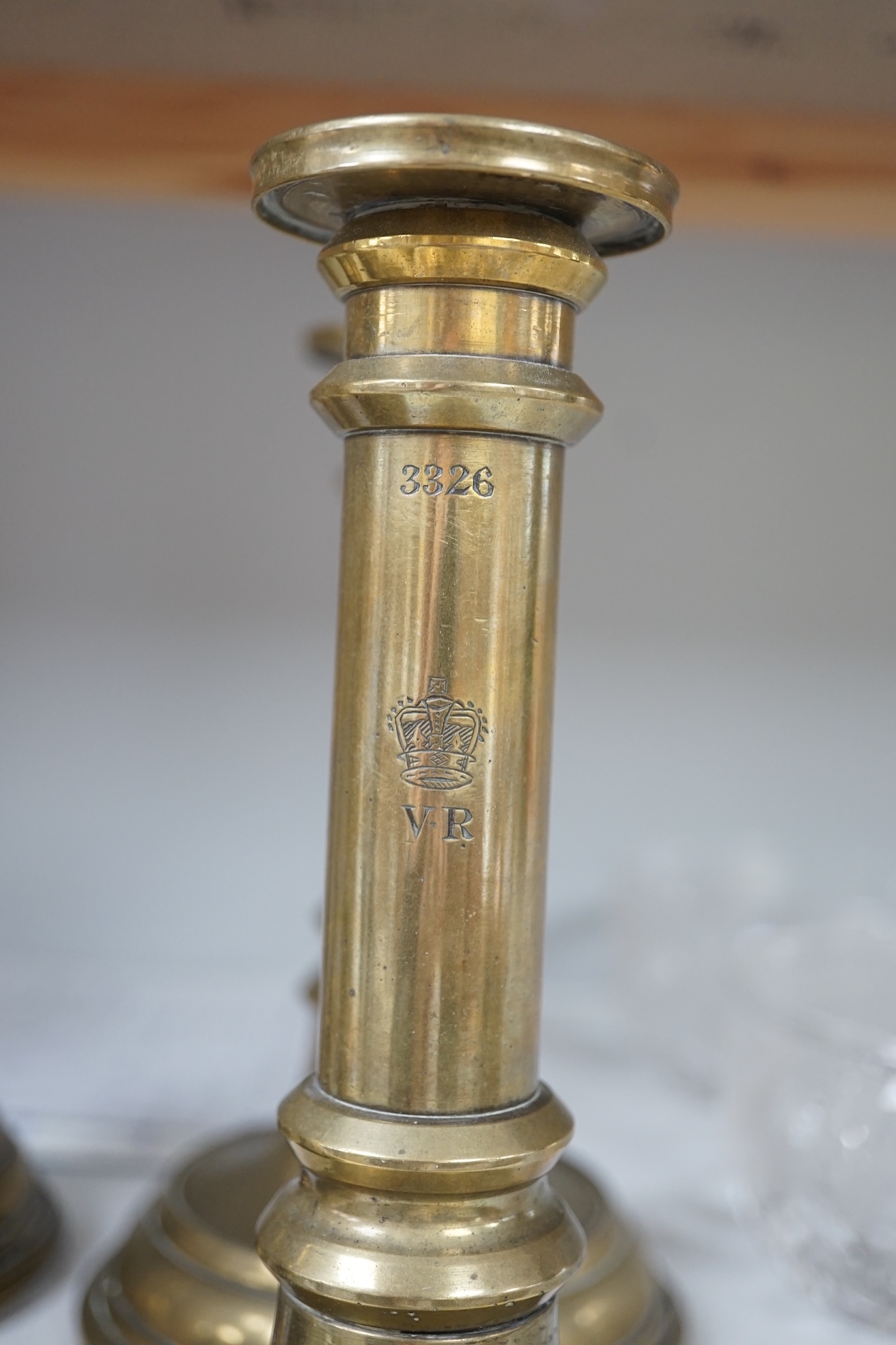 Six Victorian/William IV government issue brass candlesticks, five engraved with cipher crown and number 21.5cm high. Condition - fair.